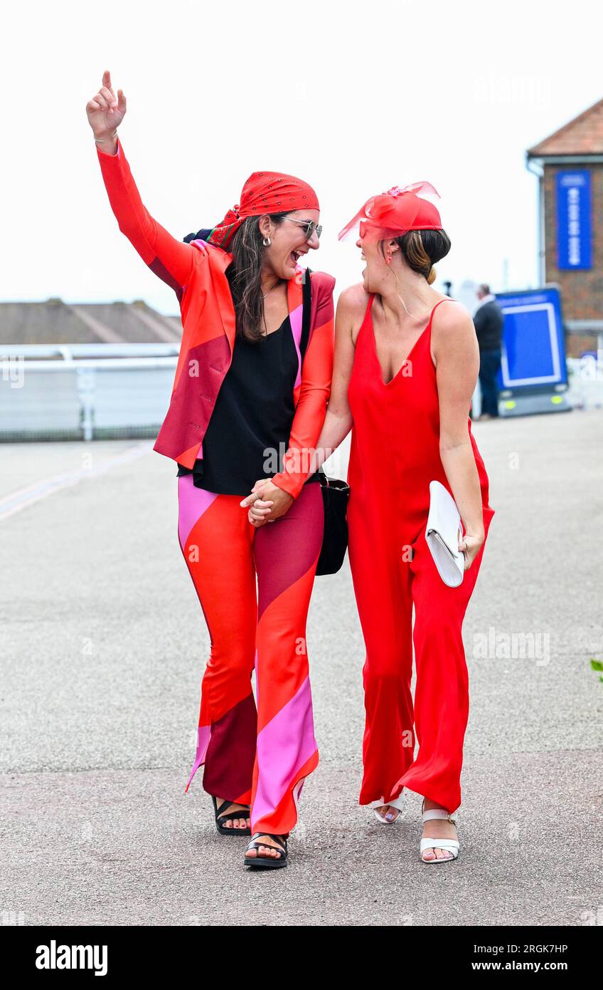 Brighton UK 10th August 2023 - Dimana  Popovska (left) and Grace Thornton in the red as they  enjoy the hot sunny weather at Brighton Races Ladies Day  during their Star Sports 3 day Festival of Racing    : Credit Simon Dack / Alamy Live News Stock Photo