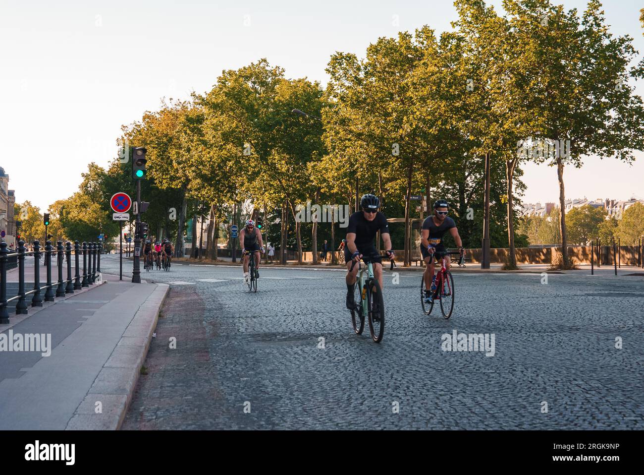 Cyclists on Sunny Paris Street Stock Photo