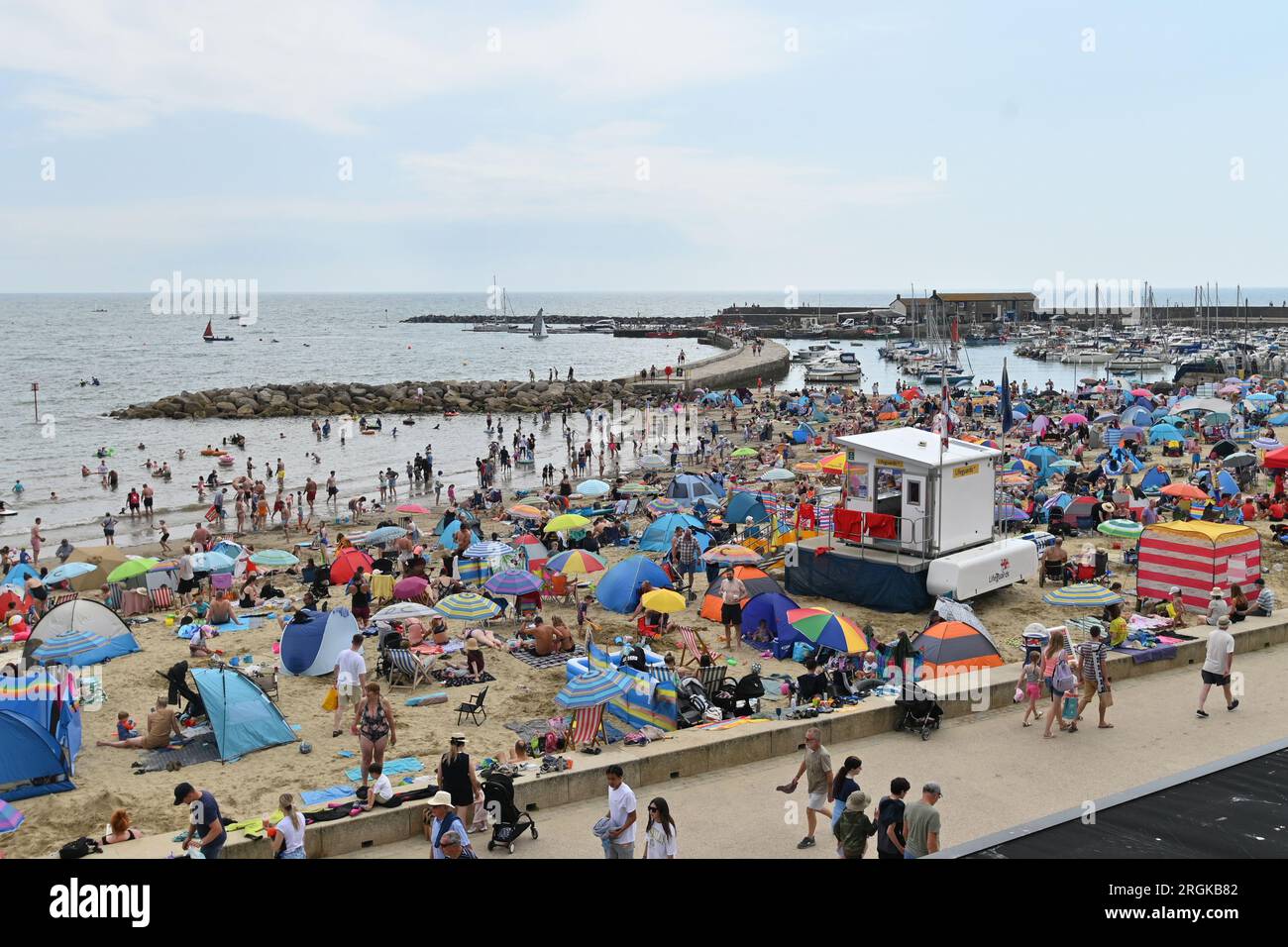 Lyme Regis. On a very hot and humid afternoon hundreds of people are seen on a fully packed beach and in the sea and sailing yachts' .Picture Credit: Robert Timoney/Alamy Live News Stock Photo