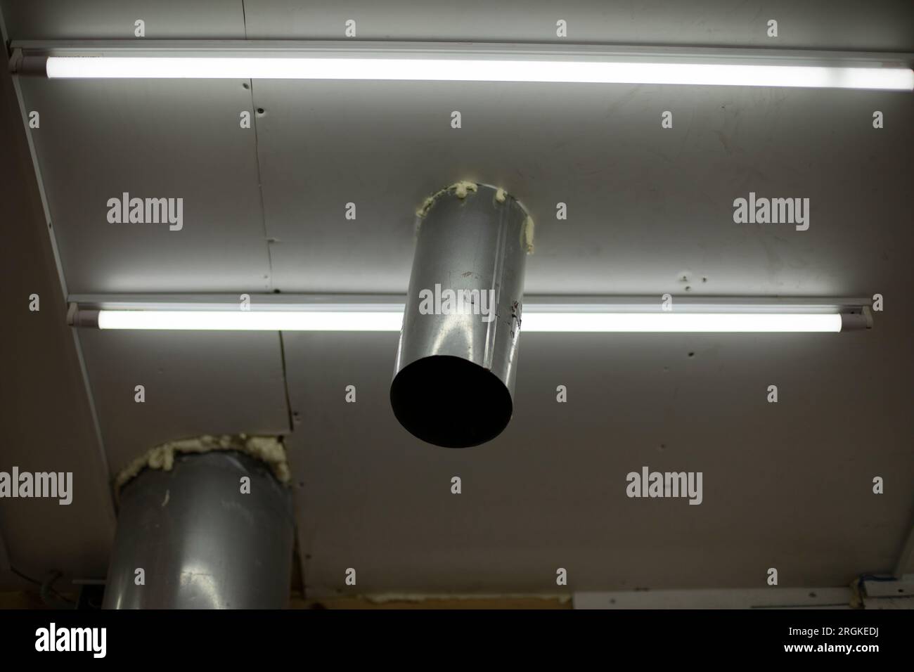 Pipe in ceiling. Pipe comes out of roof inside. Steel profile. Ceiling with hole Stock Photo Alamy
