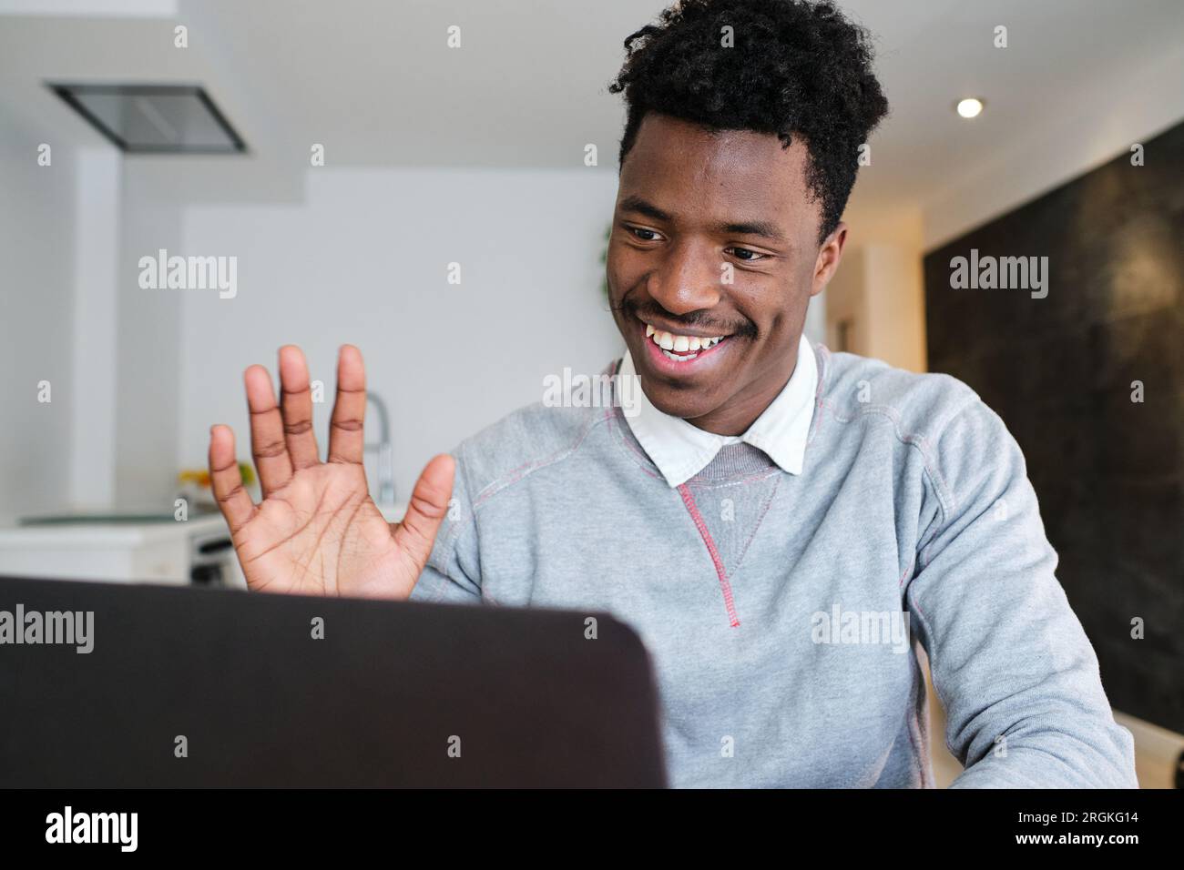 Content African American male waving hand against netbook during video ...