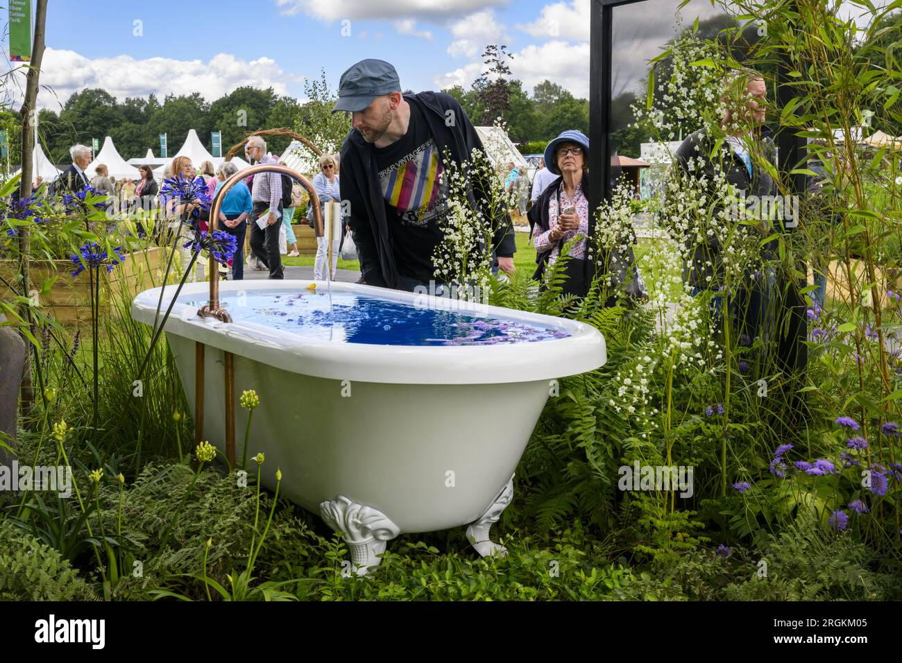 Person looks at water feature bath centrepiece (horticultural competition winner) - RHS Tatton Park Flower Show 2023 showground, Cheshire, England UK. Stock Photo