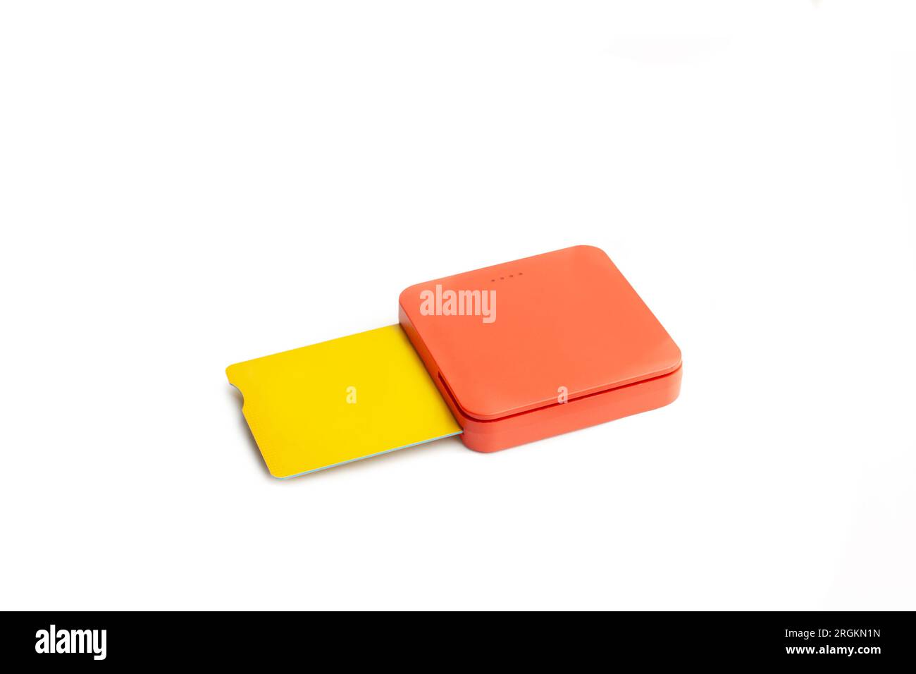 An orange card reader with a yellow credit card on a white background with copy space Stock Photo