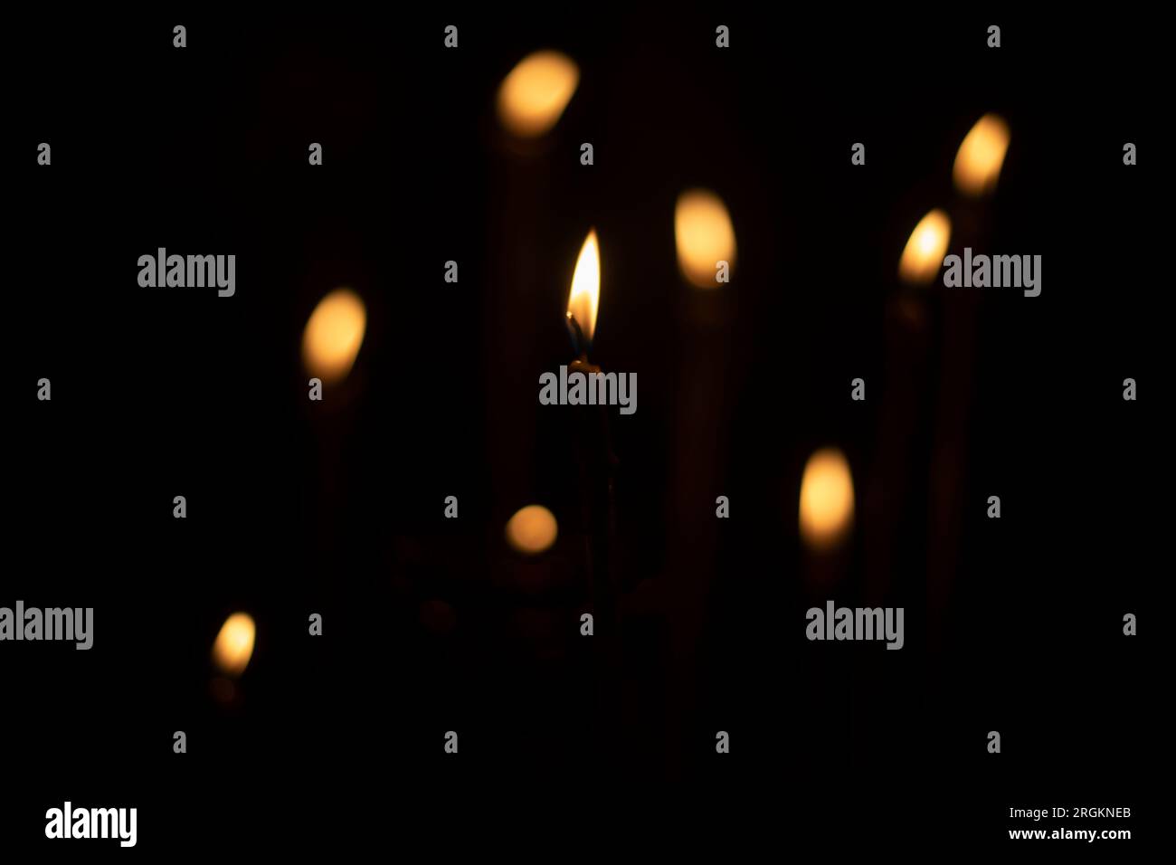 Candles burn in dark. Candle lights. Flames on black background. Yellow