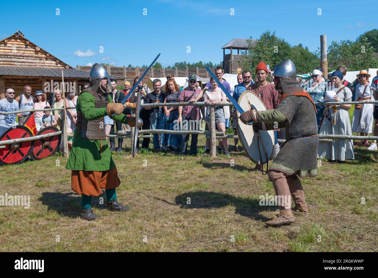 SHEVELEVO, RUSSIA - AUGUST 05, 2023: Duel of two swordsmen of the early medieval era. Historical festival 'Prince's Brotherhood'. Novgorod region Stock Photo
