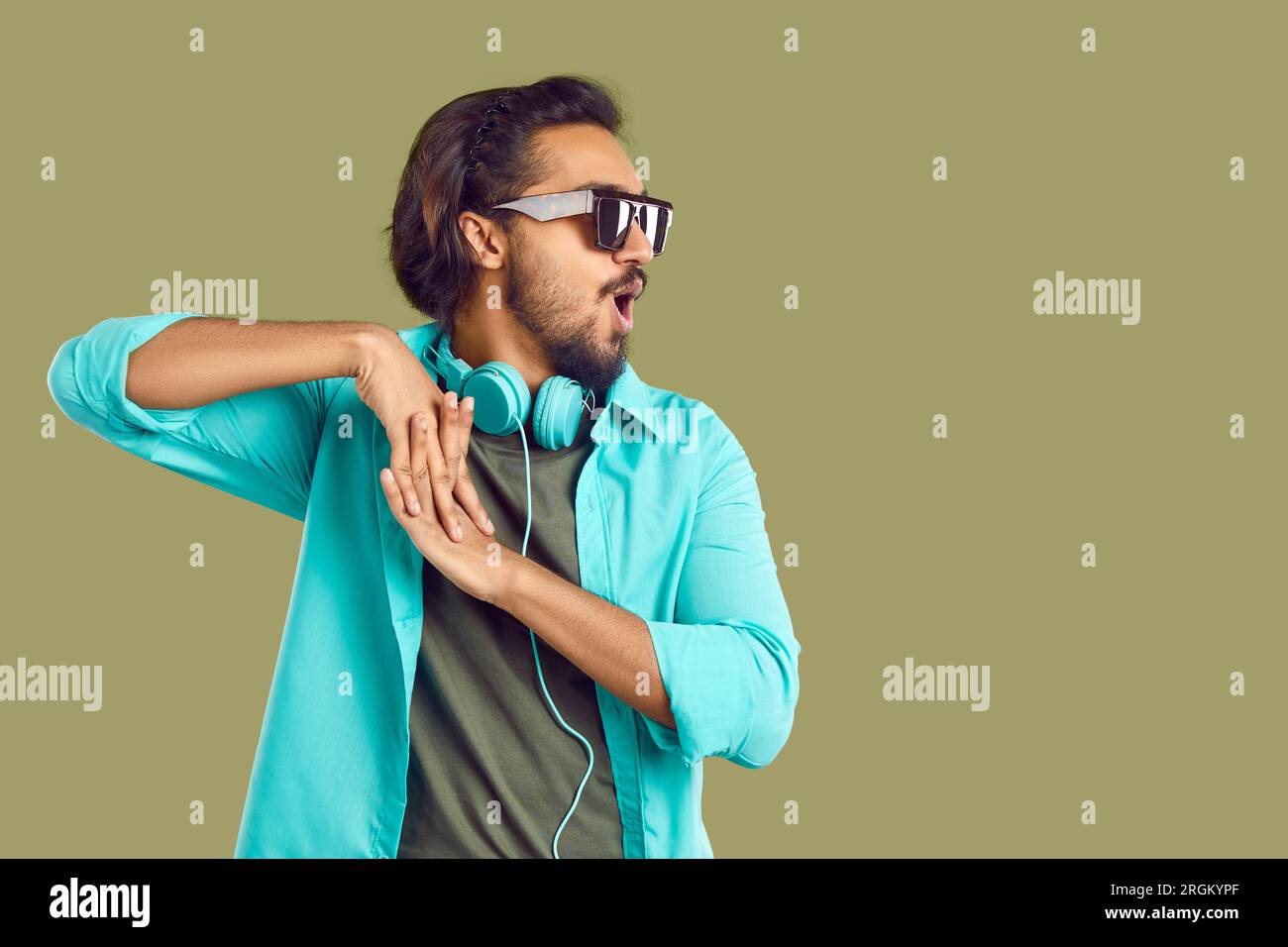 Cheerful indian man with headphones around his neck having fun dancing