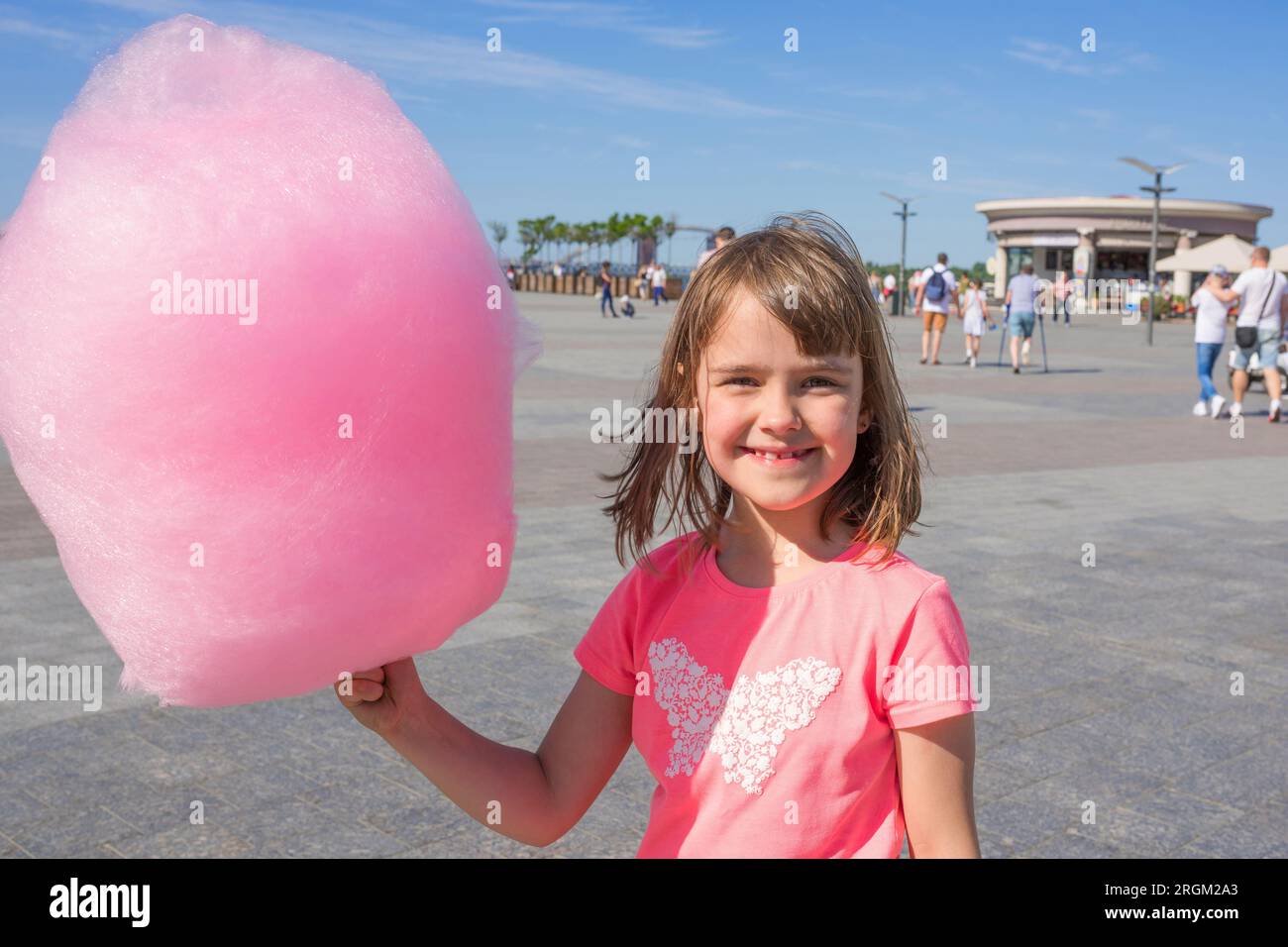 Happy girl holding cotton candy in an amusement park Stock Photo - Alamy
