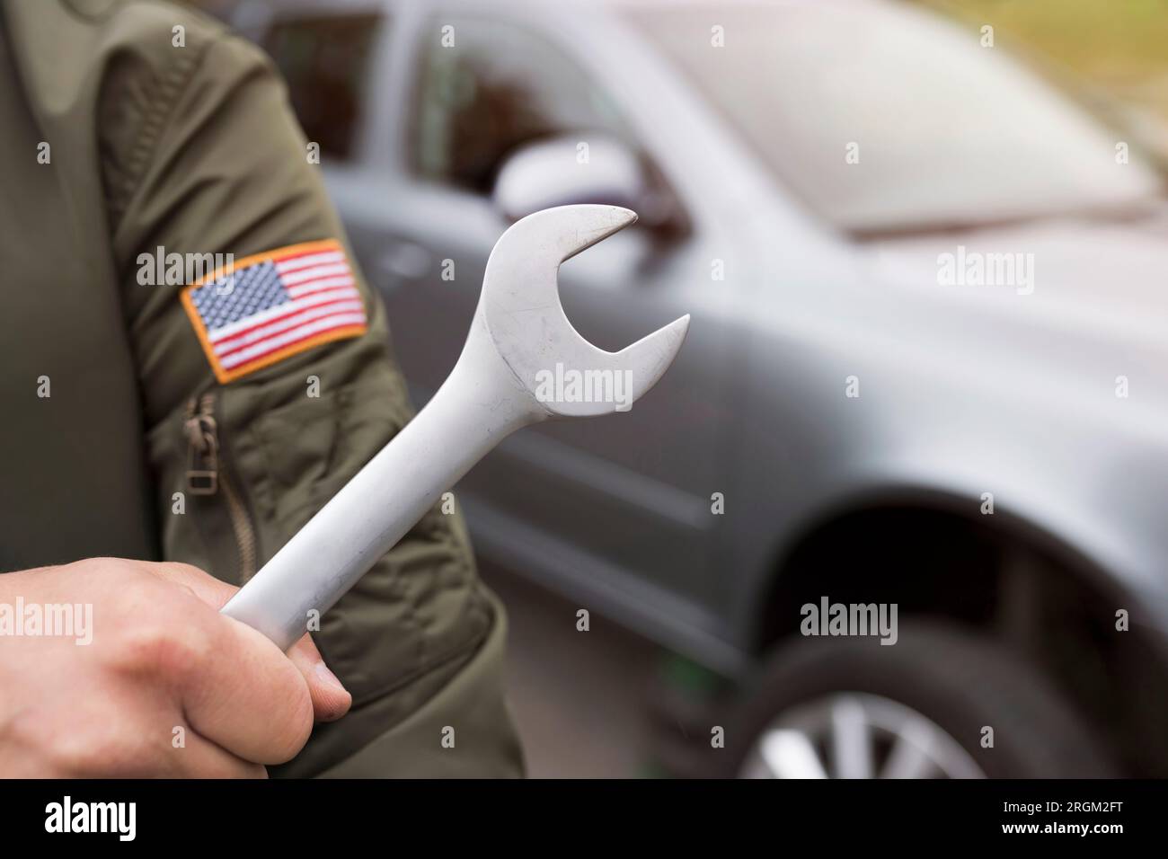 Wrench and auto mechanic hand on car background. Automobile Repair