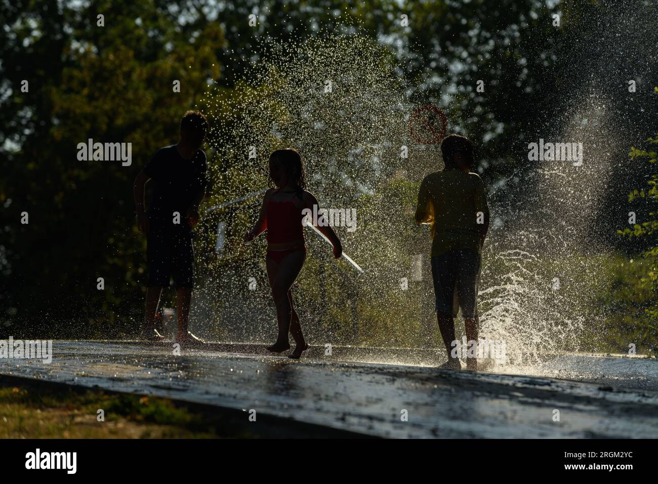 Children playing water in scorching weather in a park. Kehl, Eurodistrict Strasbourg-Ortenau, Fribourg-en-Brisgau, Bade-Wurtemberg, Germany. Stock Photo