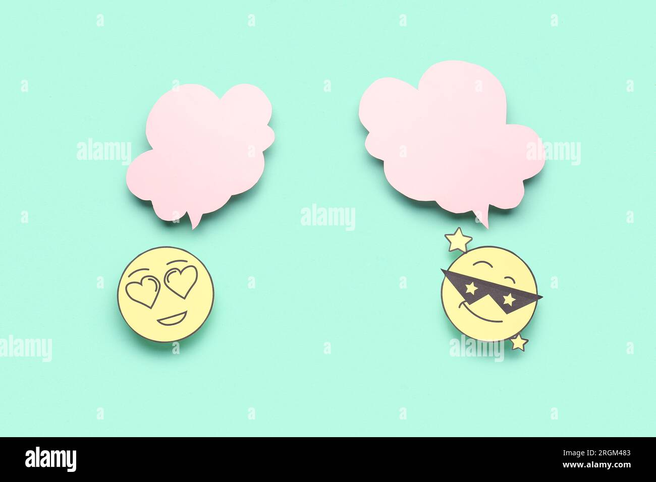 Paper faces with blank speech bubbles on turquoise background Stock Photo