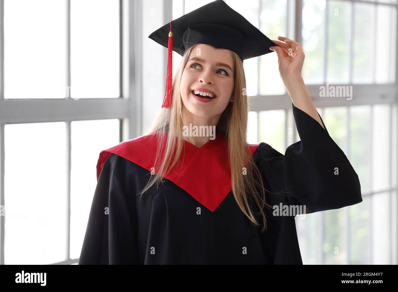 Female graduate student near window in room Stock Photo - Alamy