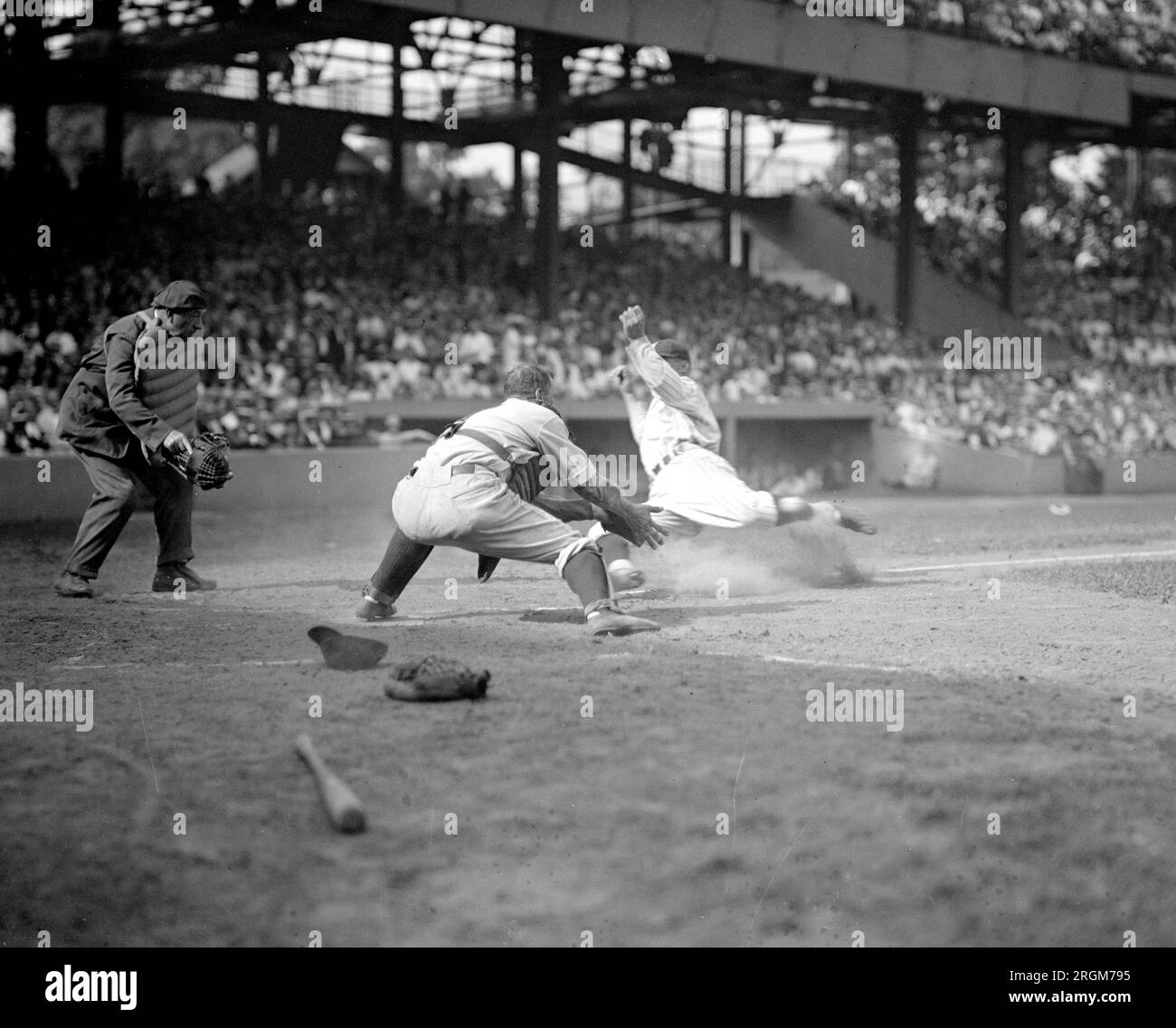 Senators Goose Goslin slides safely into home and collides with Yankees catcher Wally Schang in 2nd game of double header (baseball) ca. August 15, 1925 Stock Photo