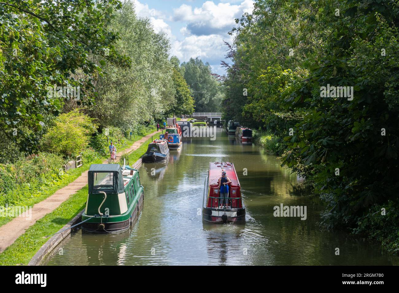 Canal boats and narrowboat approaching Kintbury Lock on the Kennet and Avon Canal in Berkshire, England, UK, during summer Stock Photo