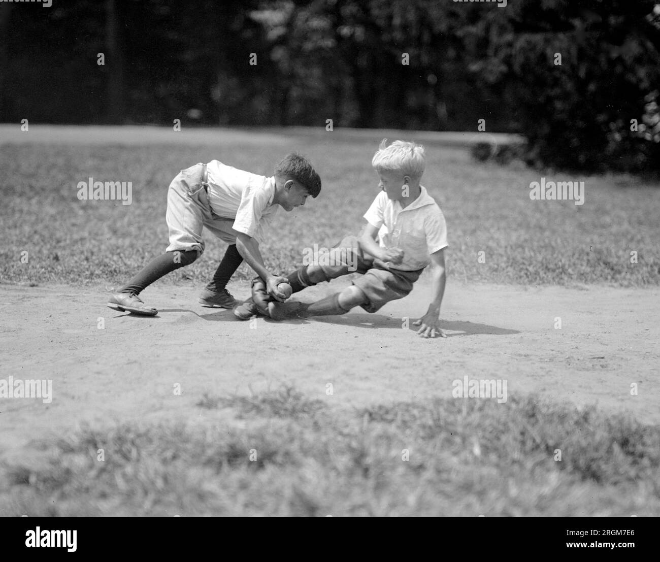 Two young boys playing baseball, an infielder tags a runner out ca. 1925 Stock Photo