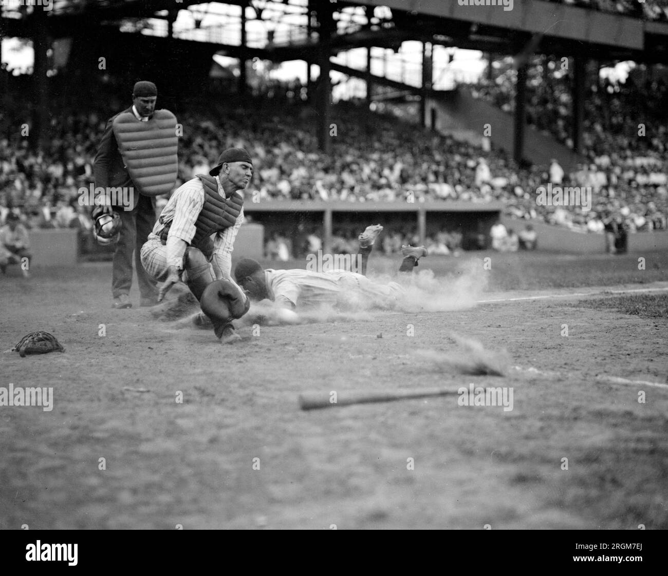 Yankees Lou Gehrig scores head first in 4th inning as Joe Harris' throw gets away from catcher Hank Severeid of Senators. Umpier is Nallin. Yanks beat Senators 3-2 (baseball) ca. August 16, 1925 Stock Photo