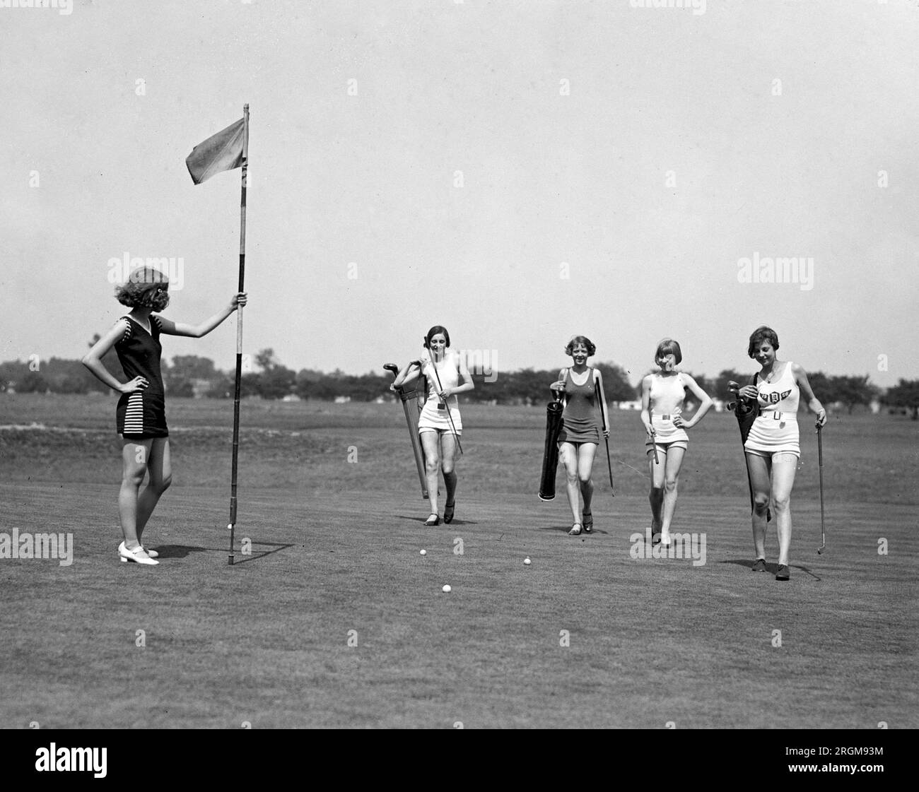 Women caddies on a golf course wearing bathing suits ca. 1926 Stock Photo