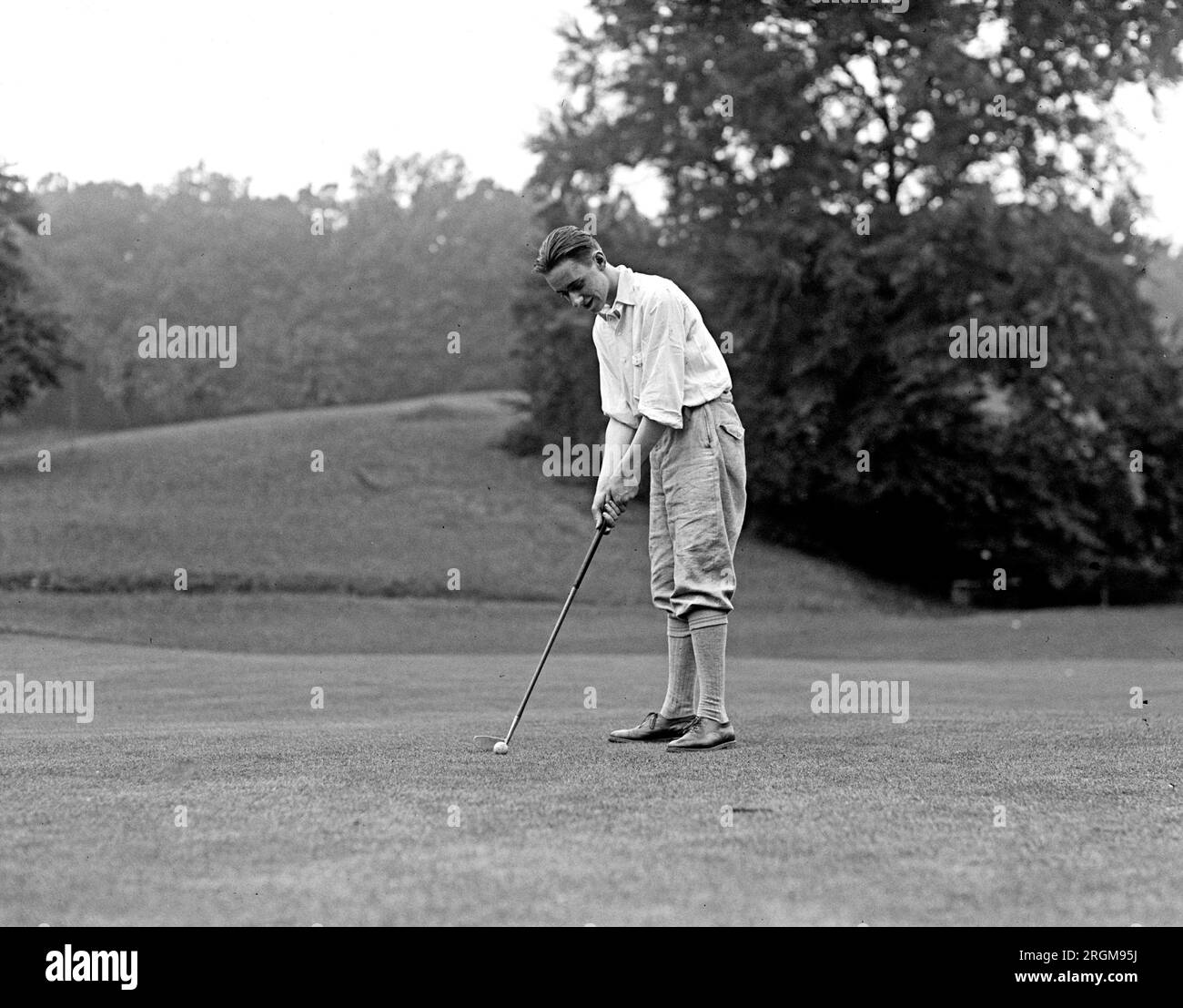 Prince Howard de Talleyrand on the golf course, preparing to putt a golf ball ca. 1926 Stock Photo