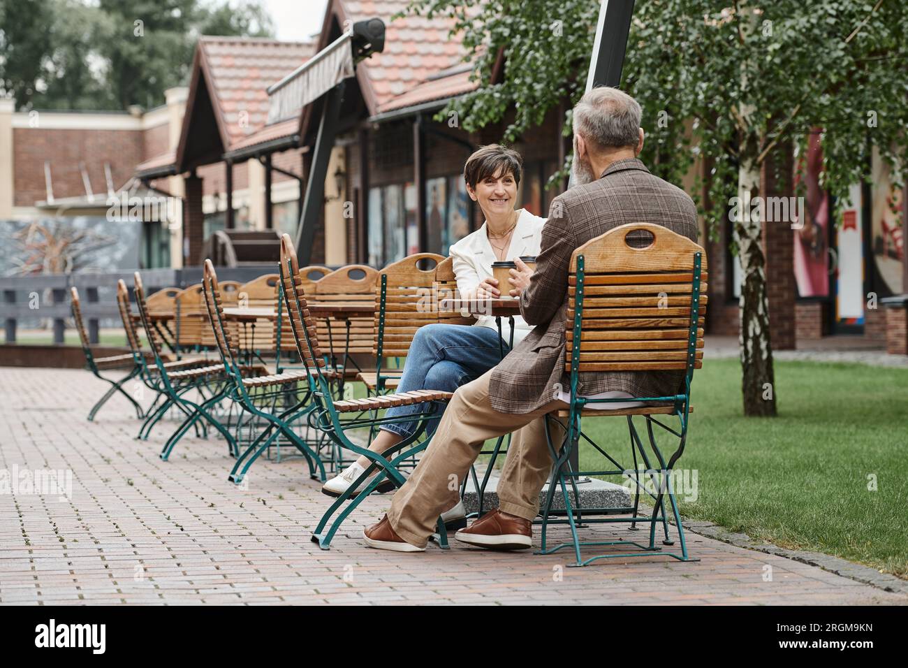 happy elderly woman and man, drinking coffee in outdoor cafe, terrace
