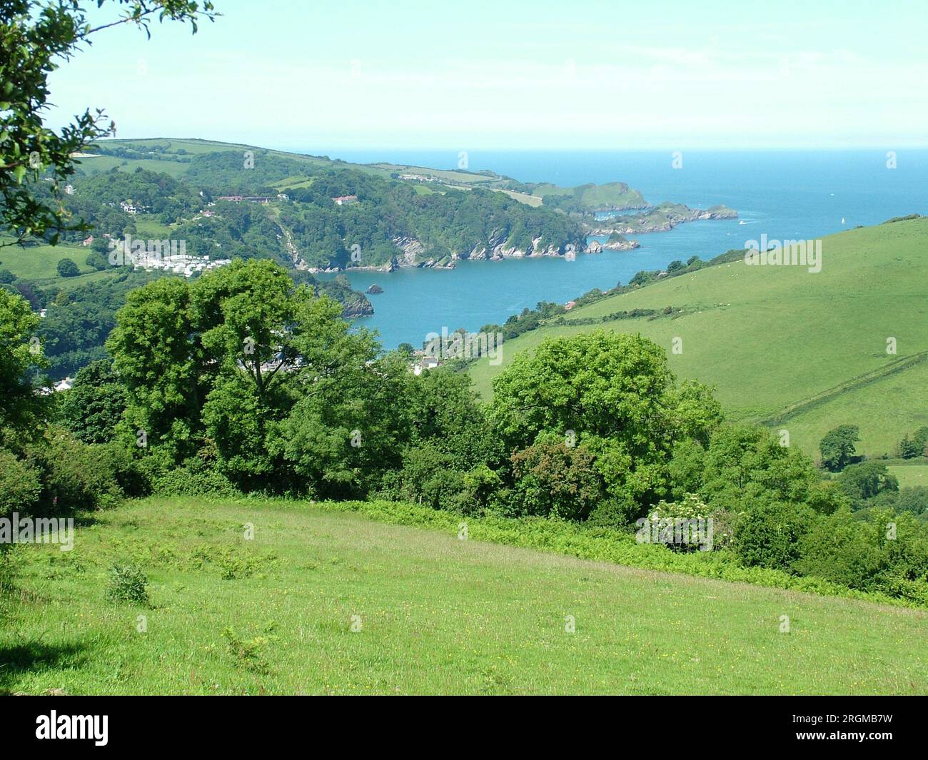 View from West Challacombe west over Combe Martin bay towards Widmouth Head on the South West coast path on a bright summers day with rolling fields Stock Photo