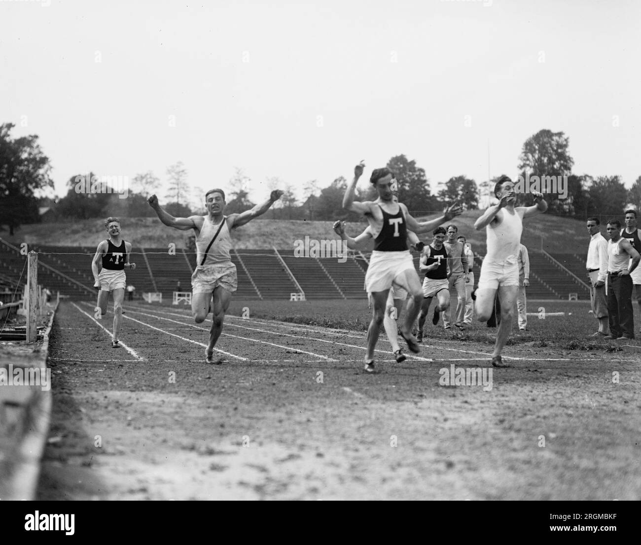 Runners finishing the crossing line during a track meet ca. 1928 Stock