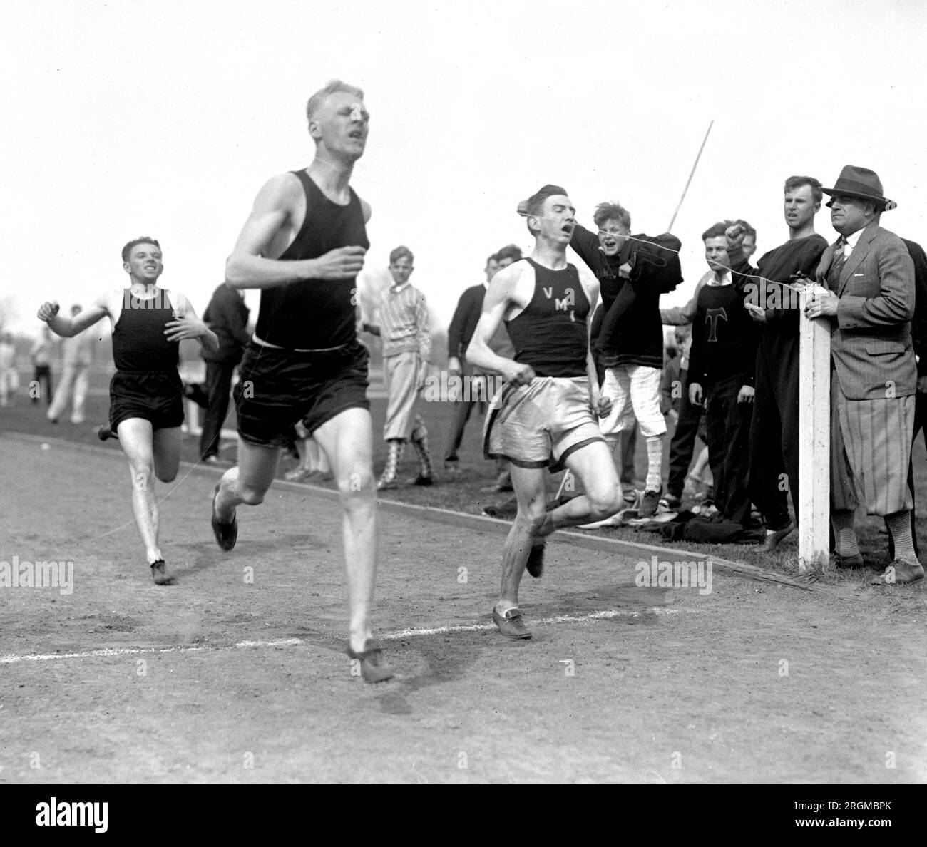 Runners crossing the finish line at a track meet between VMI and