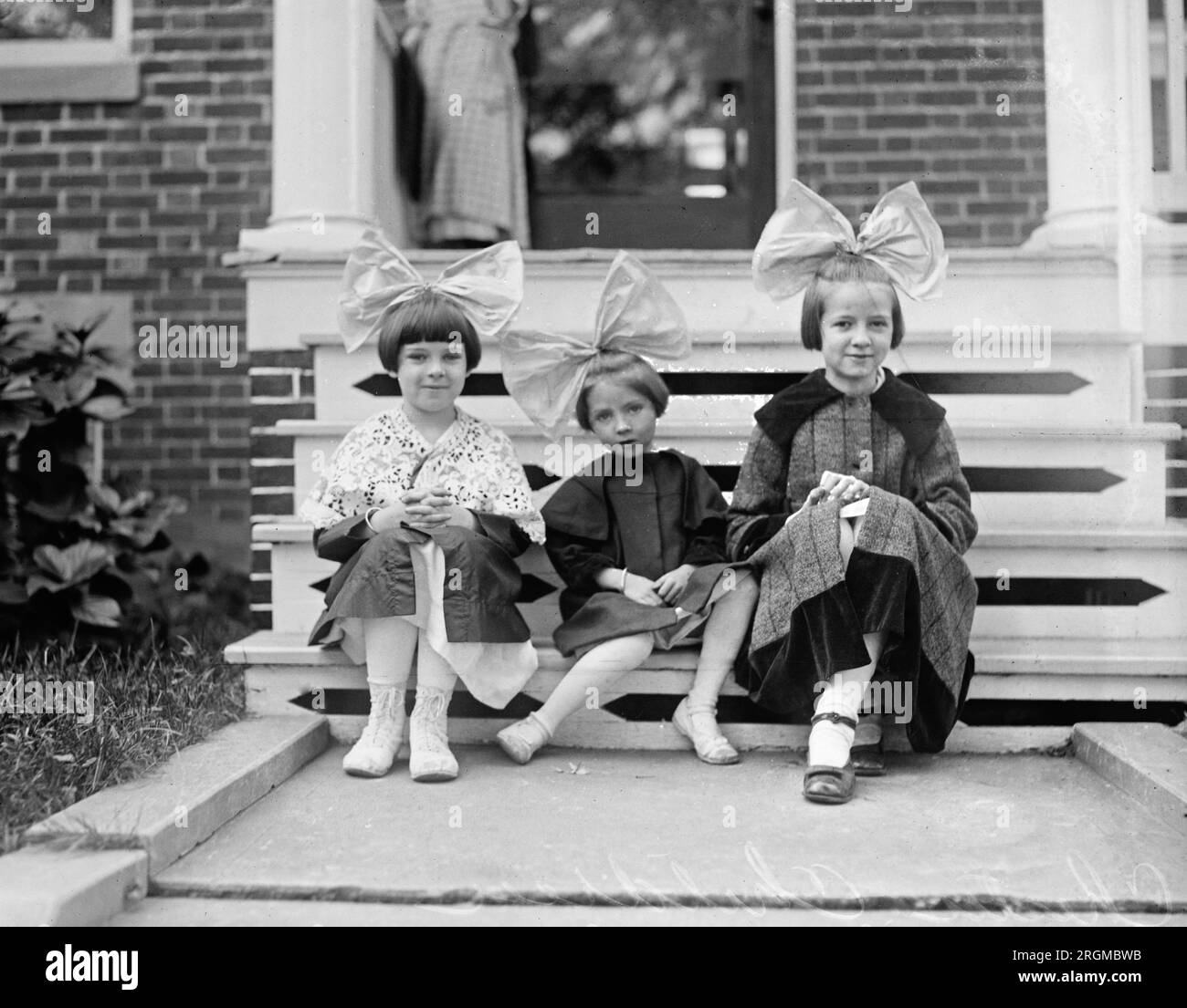 three young children sitting on a porch wearing large bows in their hair ca 1920 2RGMBWB