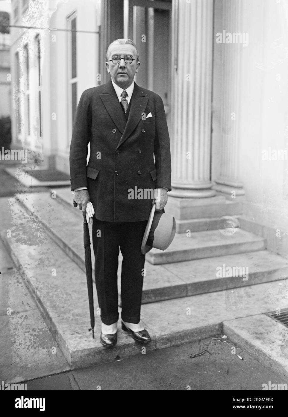 Alanson B. Houghton standing outdoors, holding an umbrella and a hat ca. 1923 Stock Photo