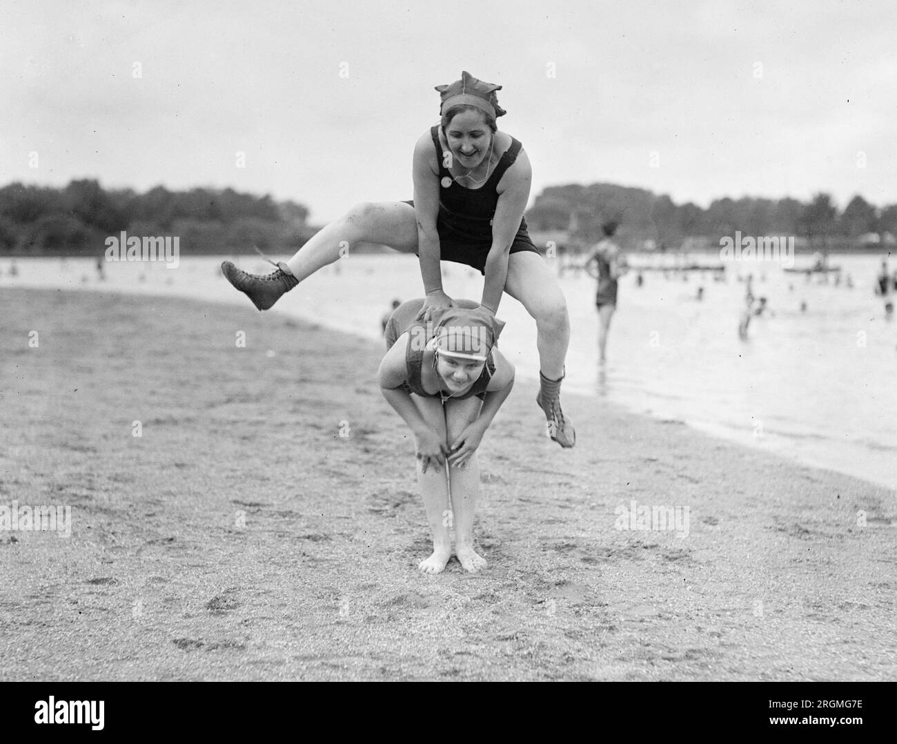 Two women playing leap frog on a beach ca. 1921 Stock Photo