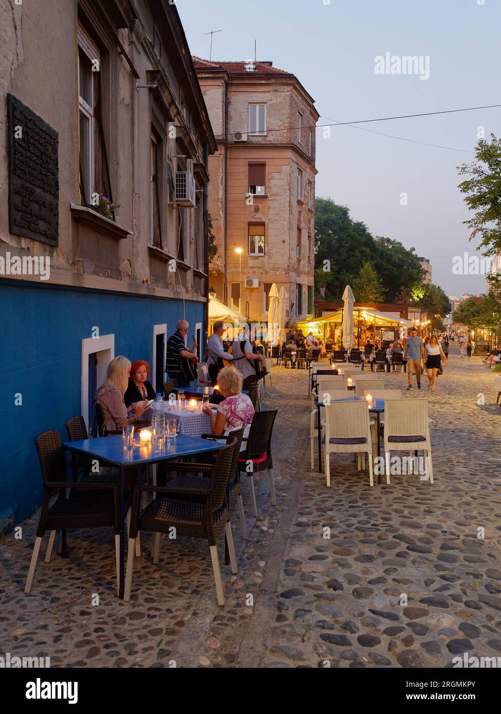 Bohemian cobbled Skadarlija street with cafes and restaurants full of people on a summers evening Belgrade, Serbia. August 10, 2023.. Stock Photo
