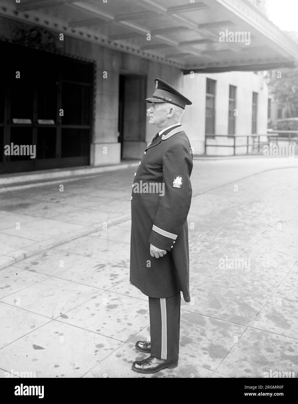 Doorman standing outside an entrance to the Mayflower Hotel, Washington, D.C. ca. 1916-1917 Stock Photo