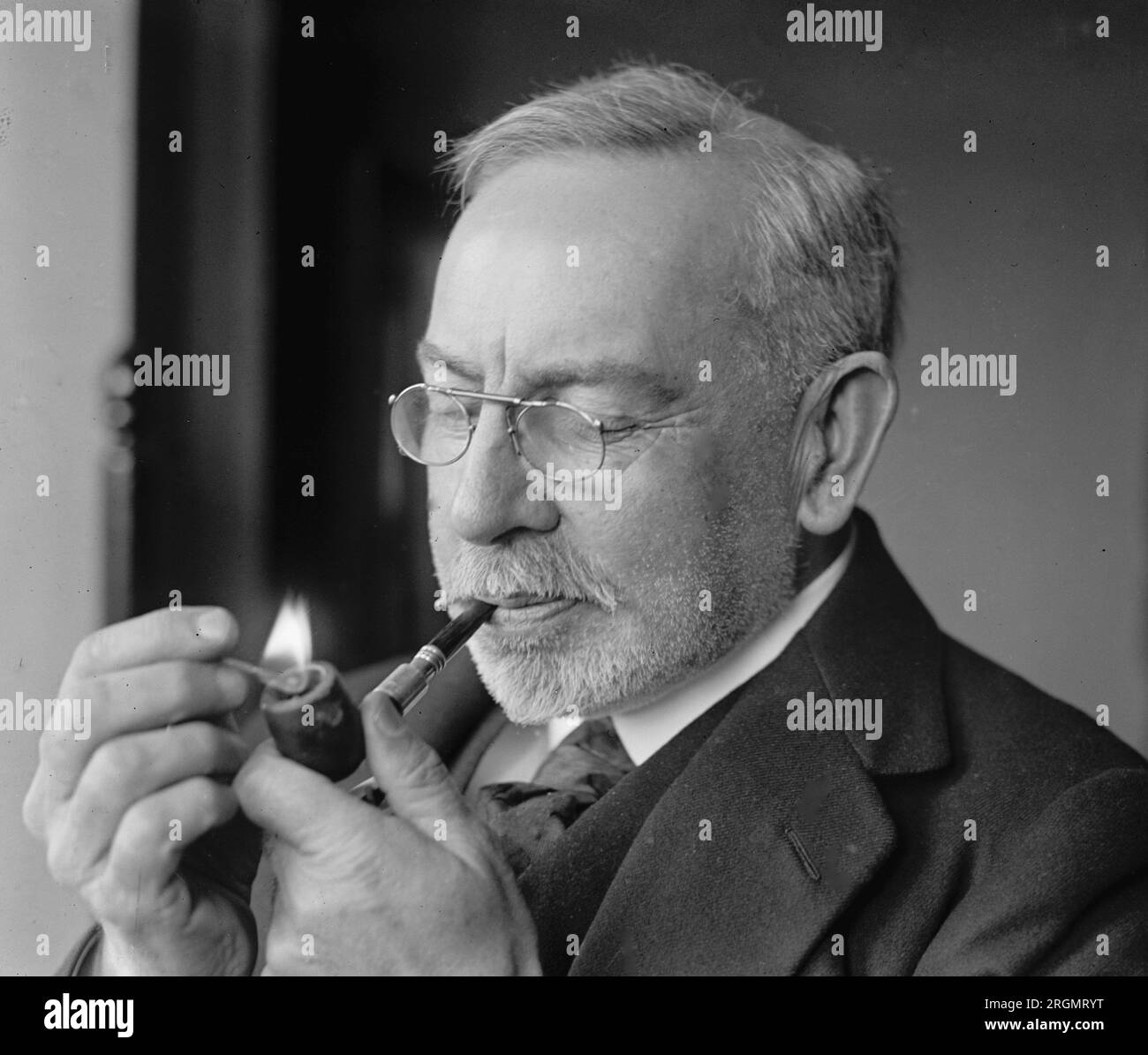 Sir John Jalmond lighting a pipe ca. 1921 Stock Photo