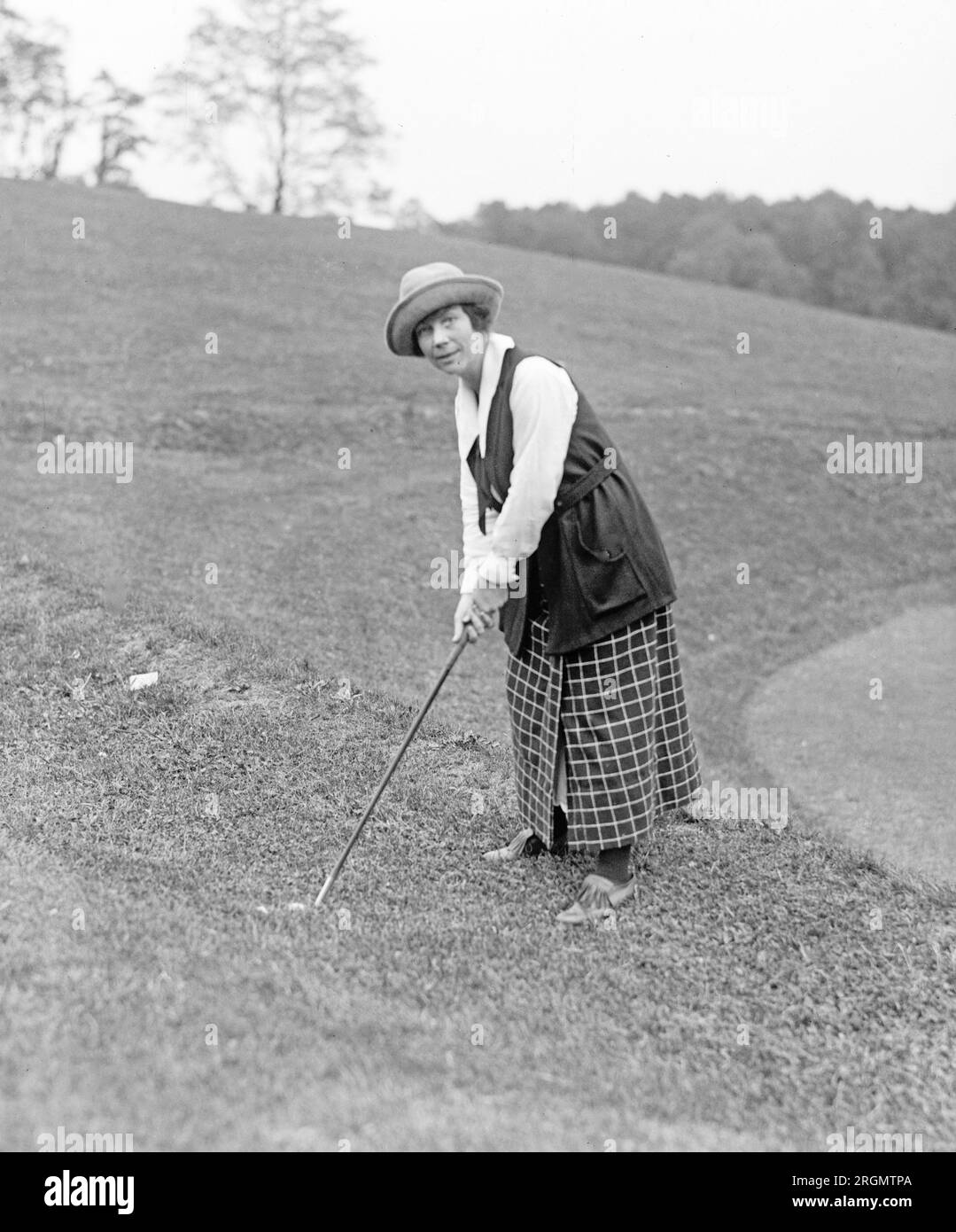 Unidentified woman golfer hitting a ball in the rough ca. 1922 Stock Photo