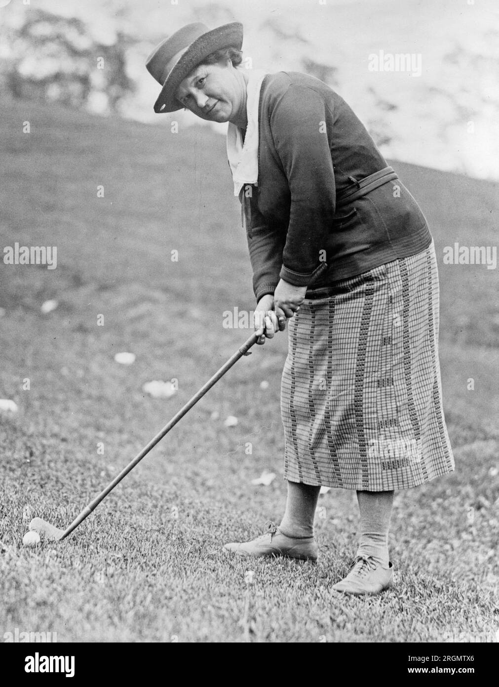 Vintage golf: Woman preparing to hit a golf ball ca. 1909-1932 Stock Photo