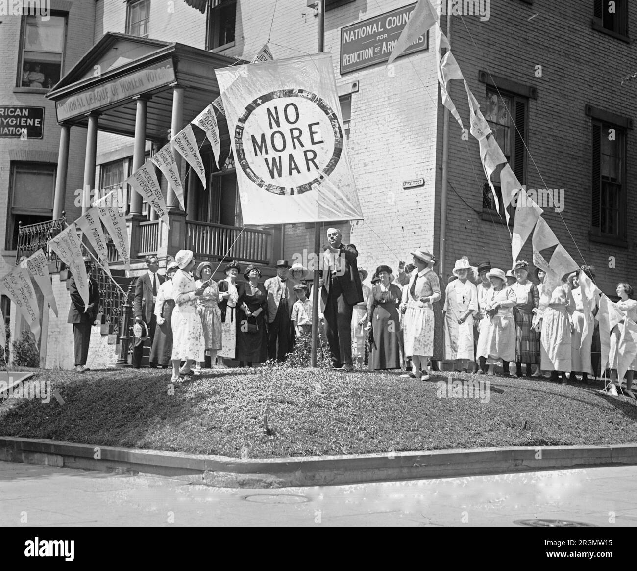 A crowd standing next to a 'No More War' banner ca. 1922 Stock Photo