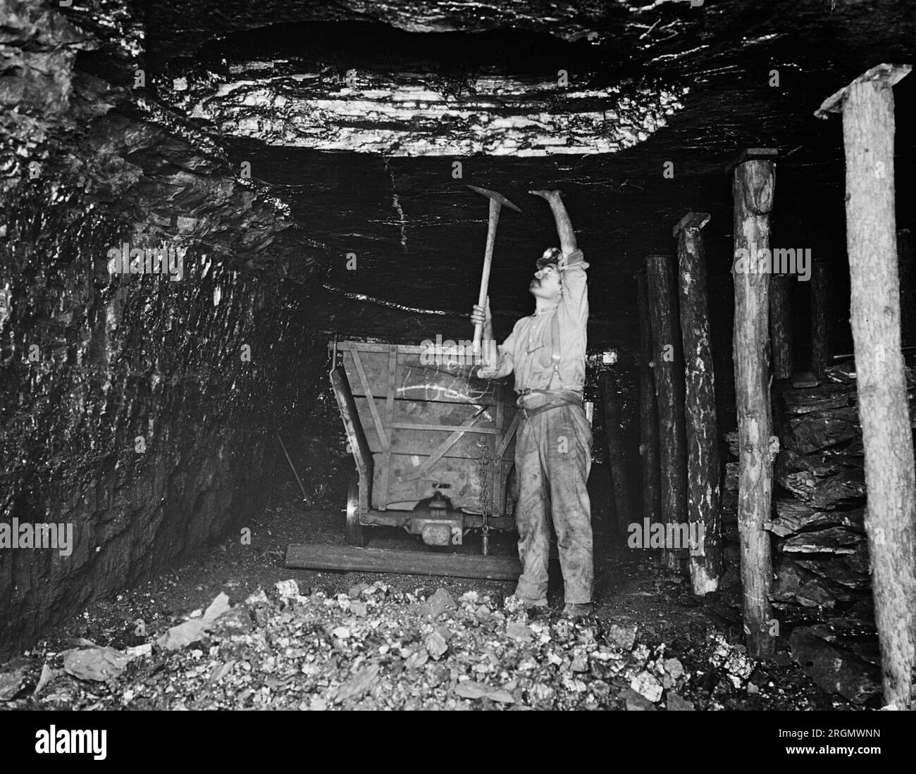 A coal miner using a pick inside a coal mine ca. 1923 Stock Photo Alamy