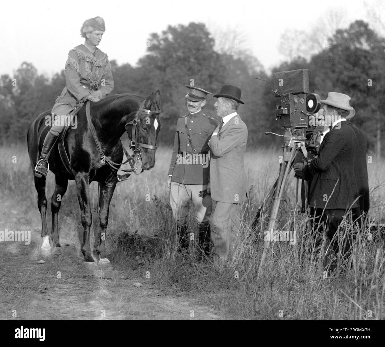 Director D.W. Griffith on location filming a movie, speaking with actors ca. 1923 Stock Photo