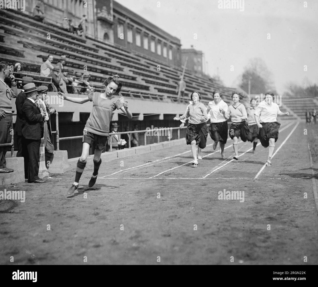 Girl athletes running at a high school track meet ca. 1925 Stock Photo