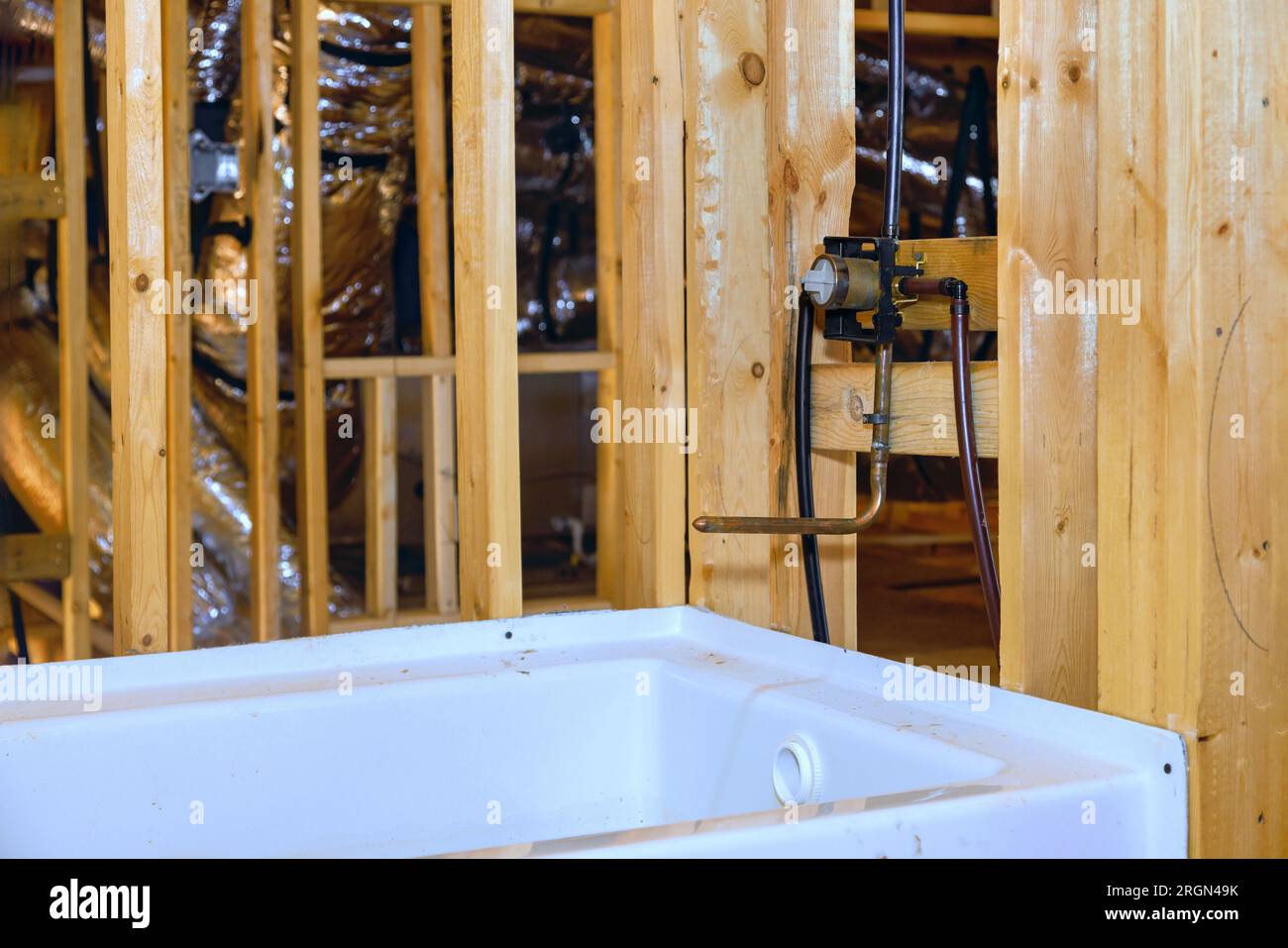 Under construction home with installed new acrylic bathtub between