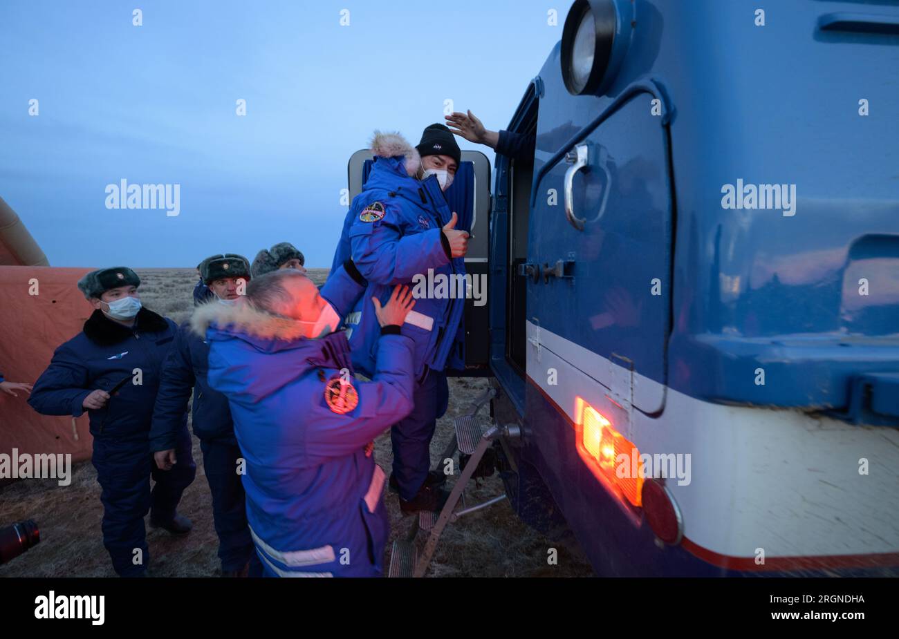 Reportage: Expedition 66 Soyuz Landing (March 2022) - Expedition 66 NASA astronaut Mark Vande Hei gives a thumbs up as he is helped aboard a Russian all terrain vehicle by NASA Astronaut Office Representative, astronaut Drew Feustel, that will take him to an awaiting helicopter. Stock Photo