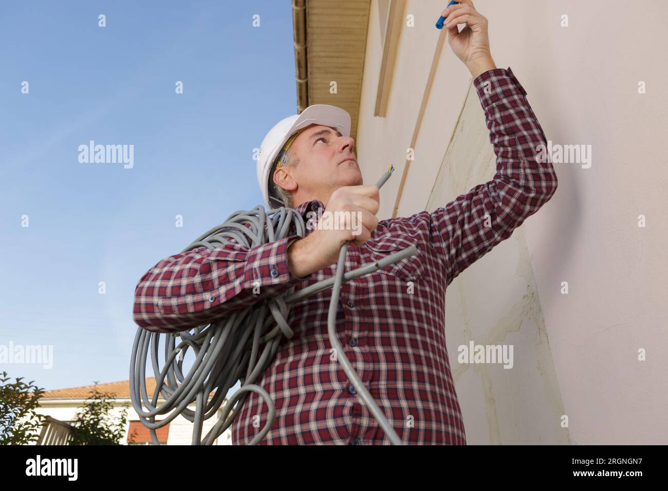 happy worker moving heavy pipes outdoors Stock Photo