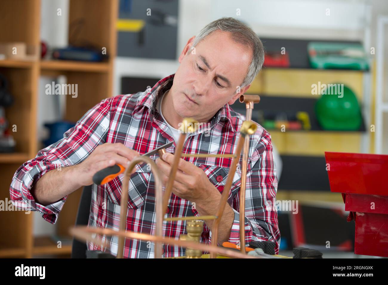 craftsman filing a copper pipe Stock Photo Alamy