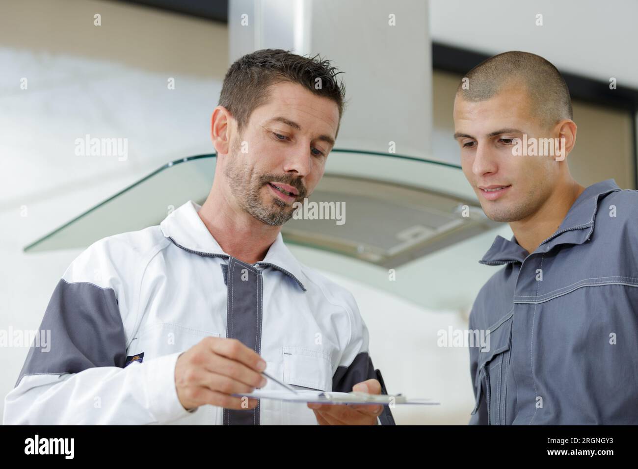 young male electrician repairing kitchen extractor filter Stock Photo