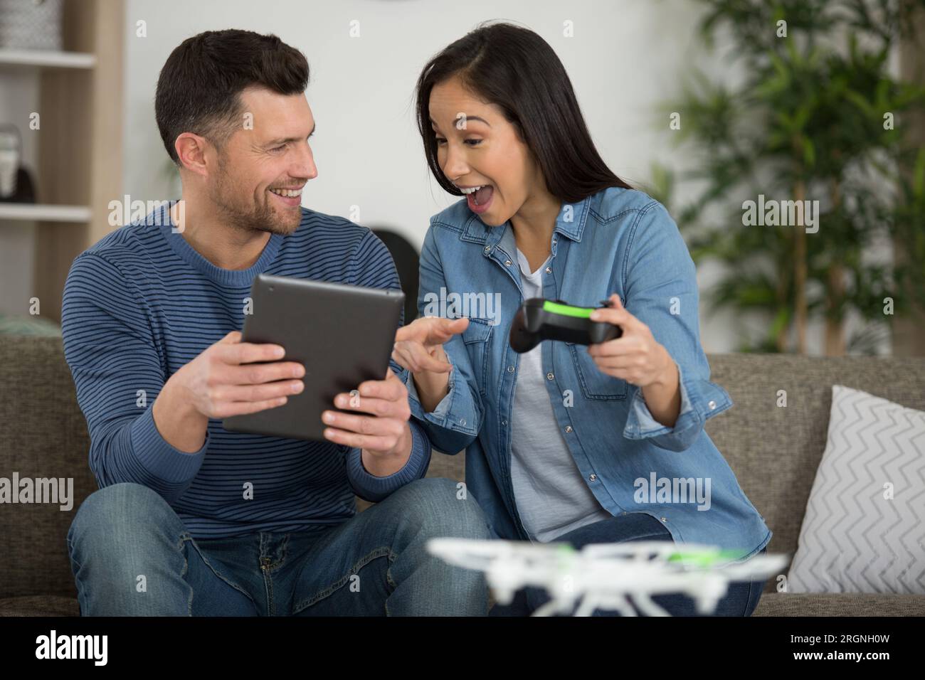 young couple playing with a small quadrocopter drone Stock Photo - Alamy