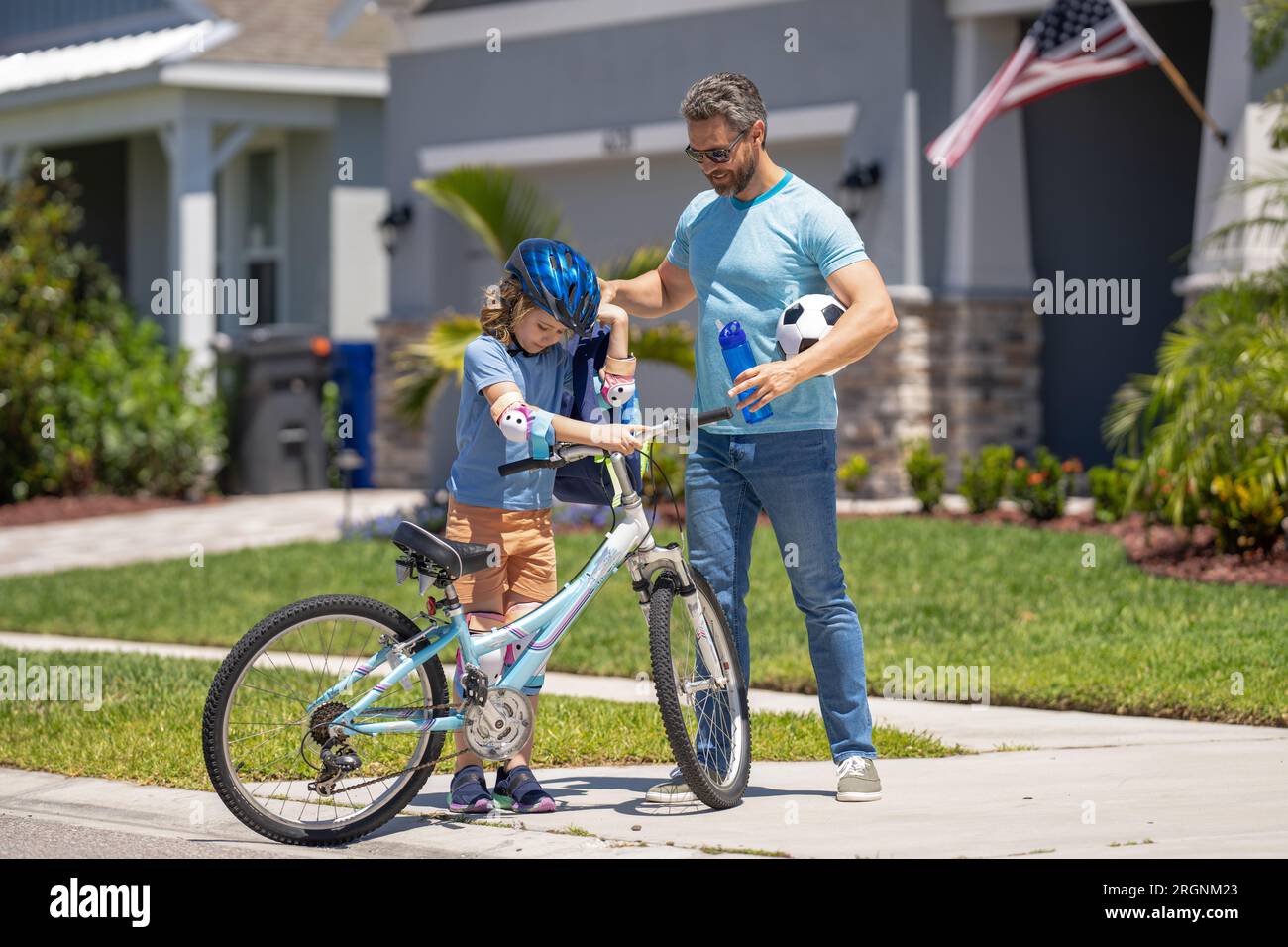 daddy and son enjoying ride together. Supportive father guiding son first bike ride. daddy and son sharing biking adventure. father and son navigate Stock Photo Alamy