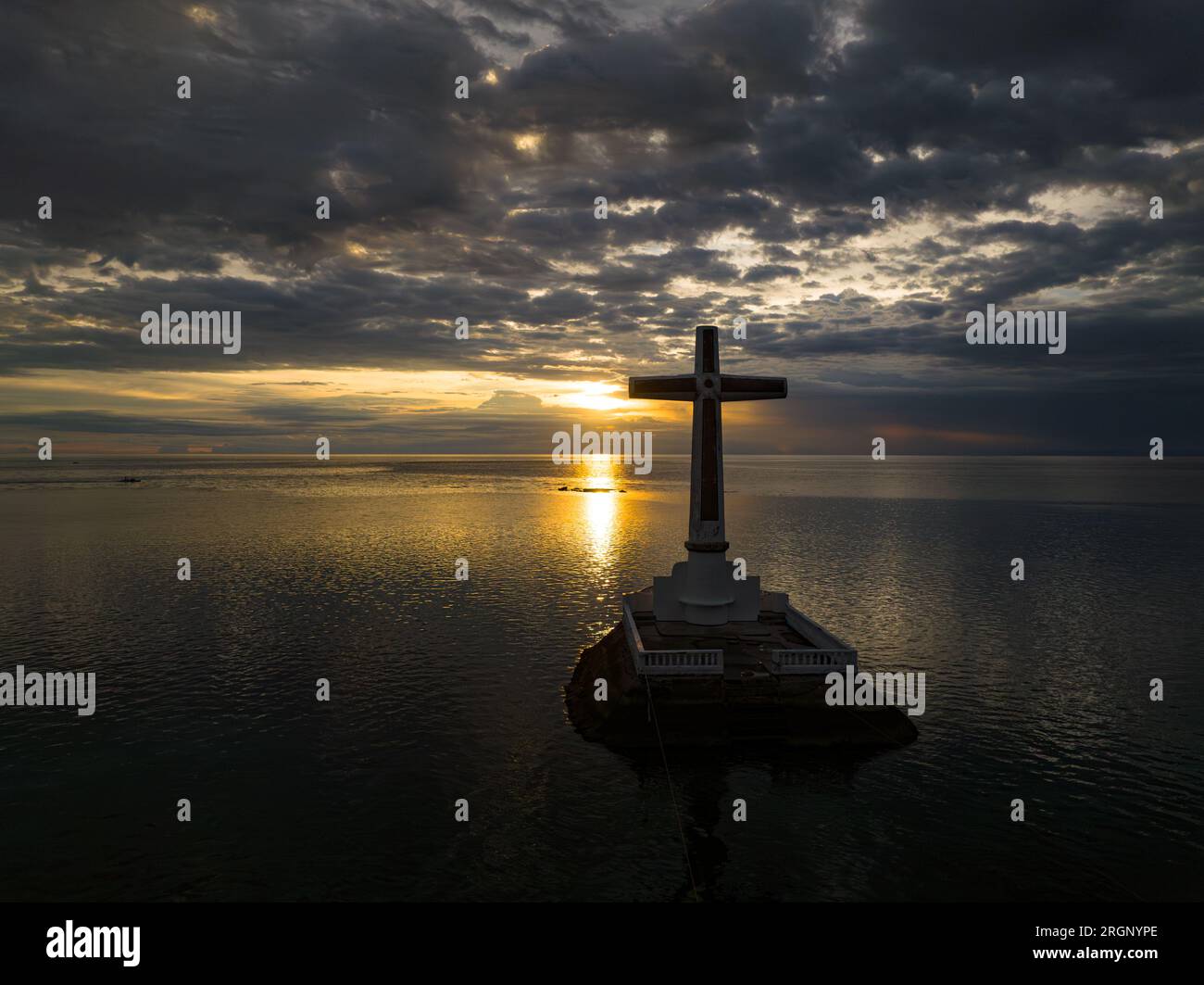 A large cross in the sea with sunset background. Sunken Cemetery in Camiguin Island. Philippines. Stock Photo