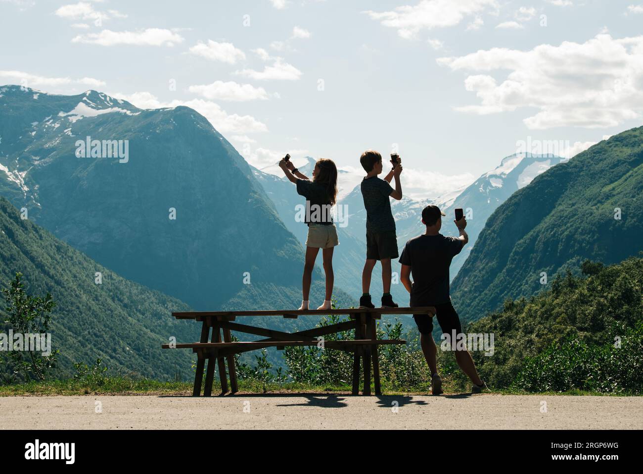 family taking pictures with their phones of a beautiful view in Norway Stock Photo