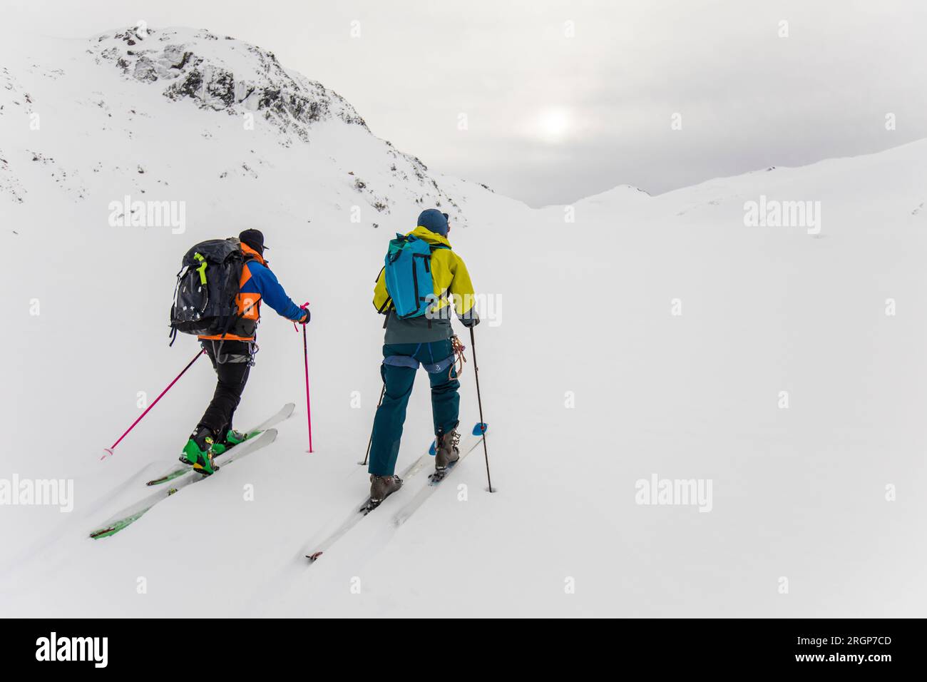 Rear view of two men with backpacks on ski touring in mountains Stock Photo