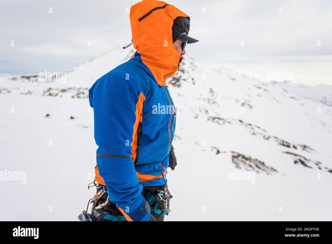Side view of man on windy mountain summit, warm clothing Stock Photo
