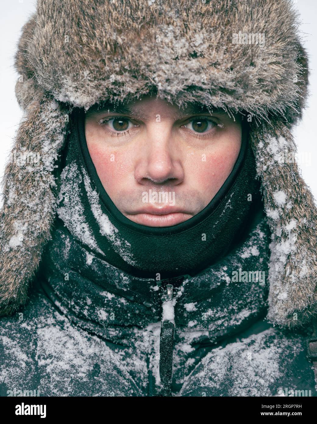 Portrait of a man with a fur hat frozen with ice and snow Stock Photo