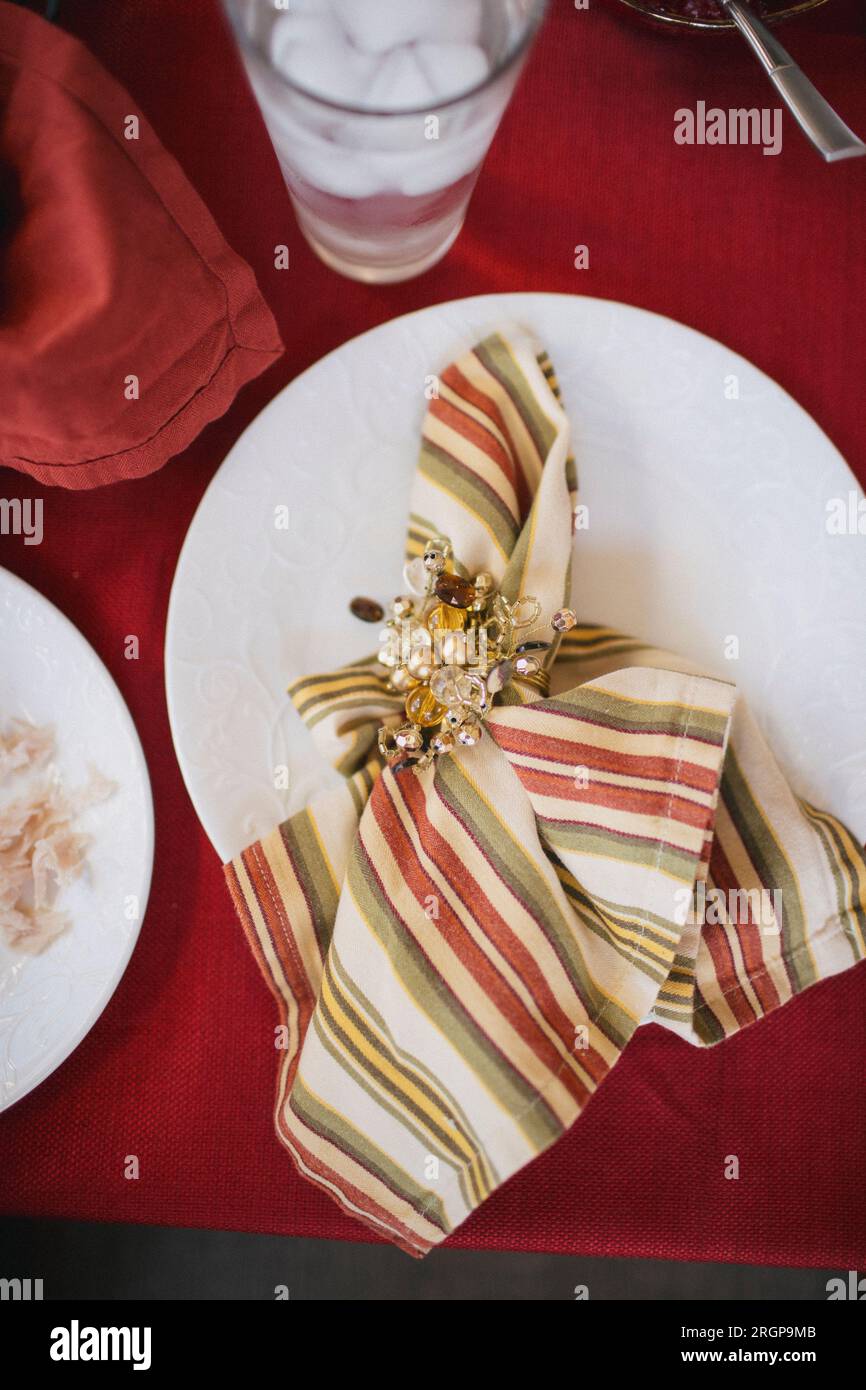 Fancy dinner napkins fill empty plates before a holiday meal Stock
